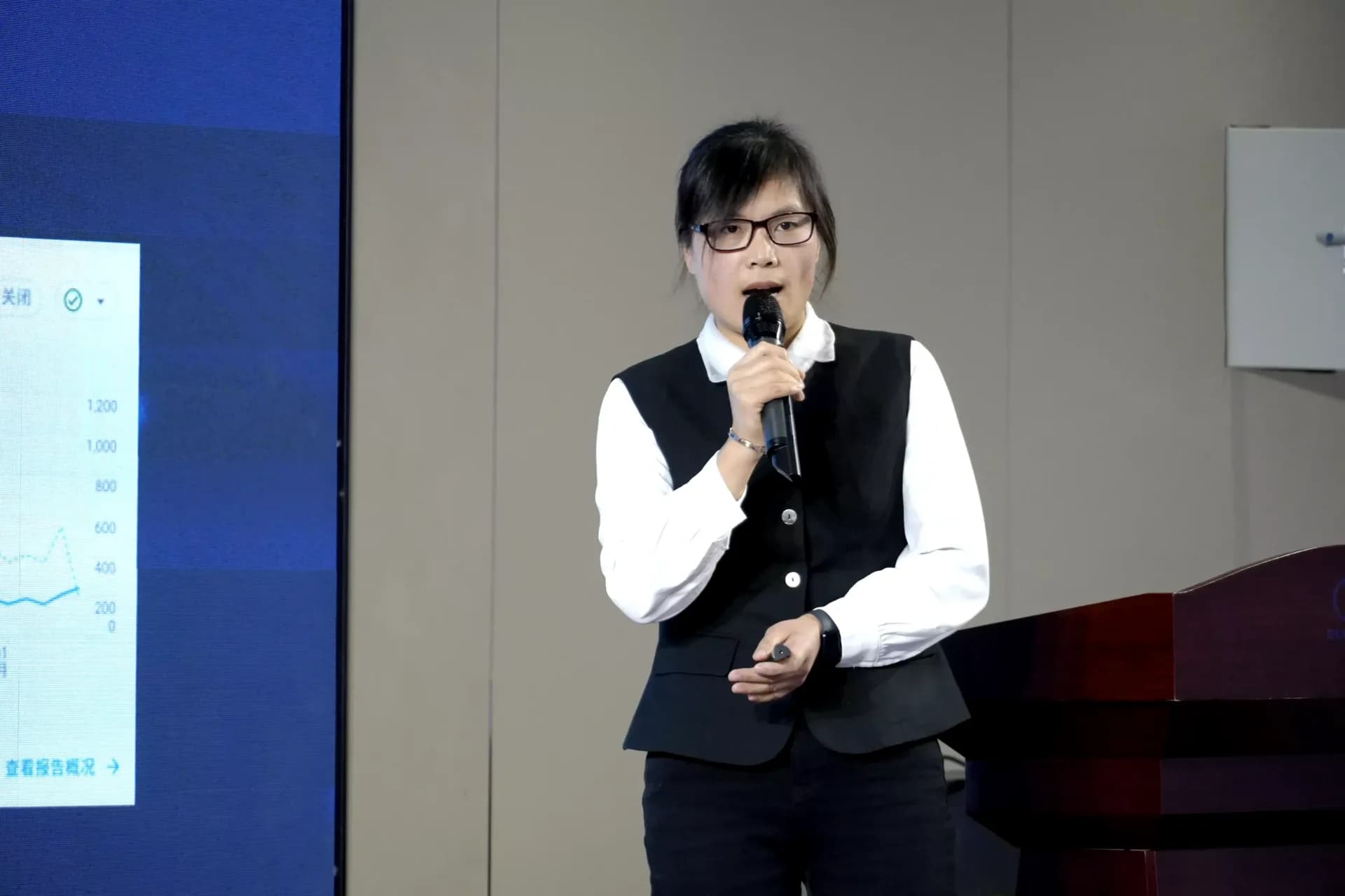 年终总结会发言者手持麦克风作报告