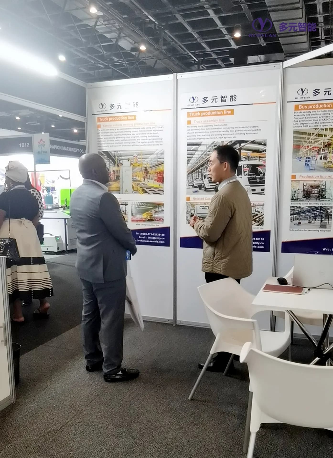 参观者在多元展位的产线介绍展板前交流