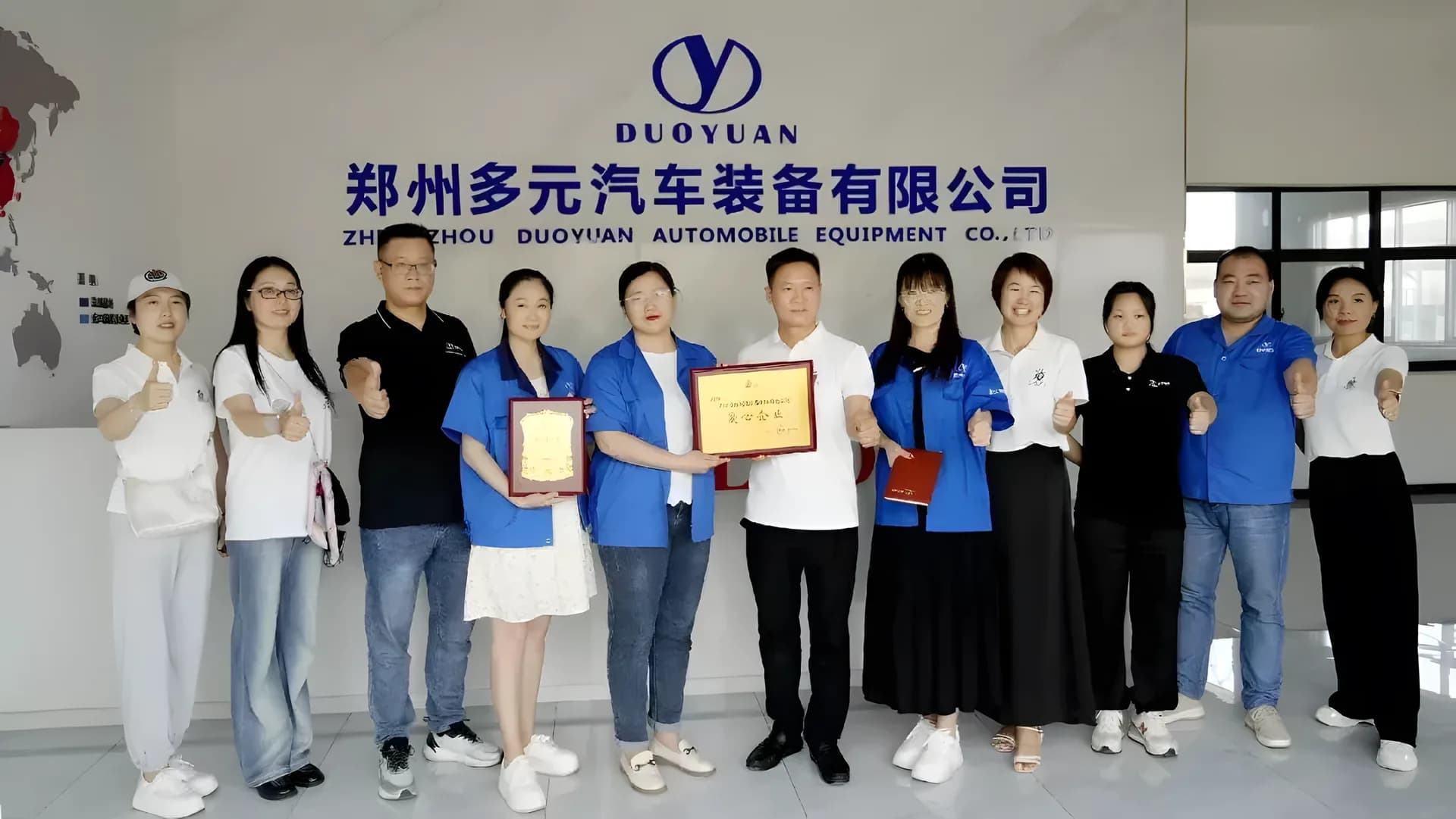 多元厂区内手持证书的集体合影